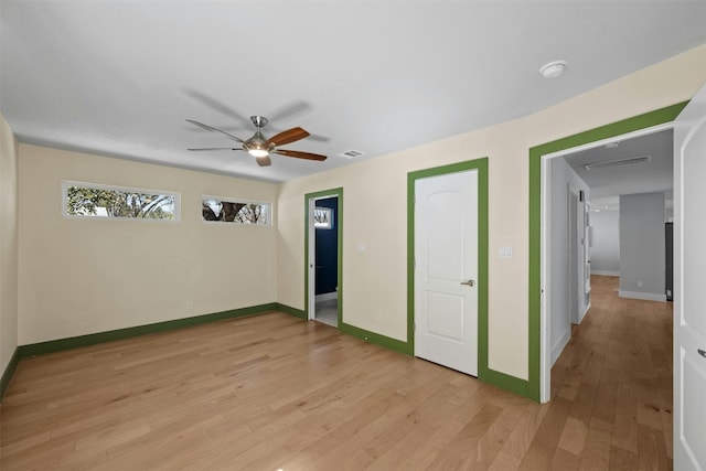 unfurnished bedroom featuring light wood-style flooring, visible vents, baseboards, and a ceiling fan