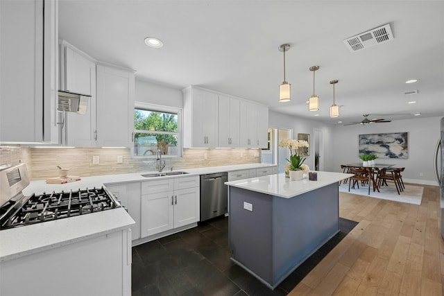 kitchen with visible vents, white cabinets, a sink, gas range, and dishwasher