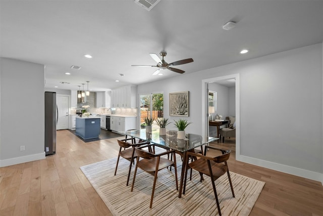 dining space featuring baseboards, light wood-style flooring, visible vents, and recessed lighting