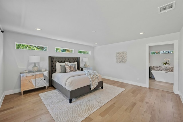 bedroom with light wood-style floors, visible vents, and multiple windows