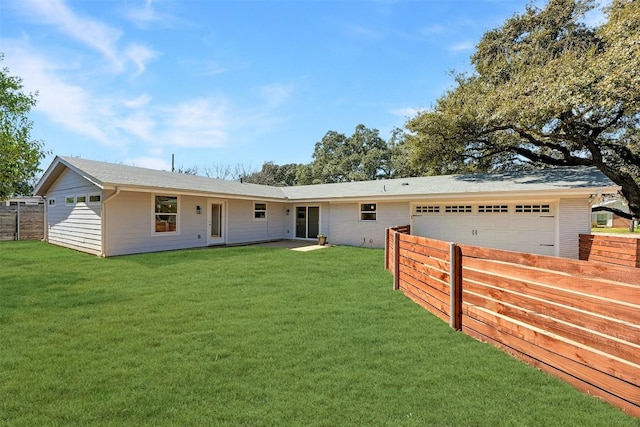 ranch-style home with an attached garage, fence, and a front yard