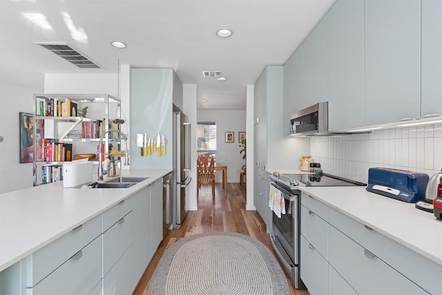 kitchen with visible vents, appliances with stainless steel finishes, tasteful backsplash, and a sink