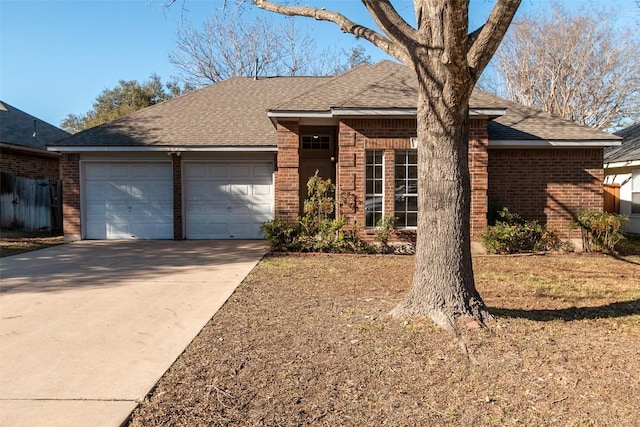 ranch-style house with brick siding, driveway, an attached garage, and roof with shingles