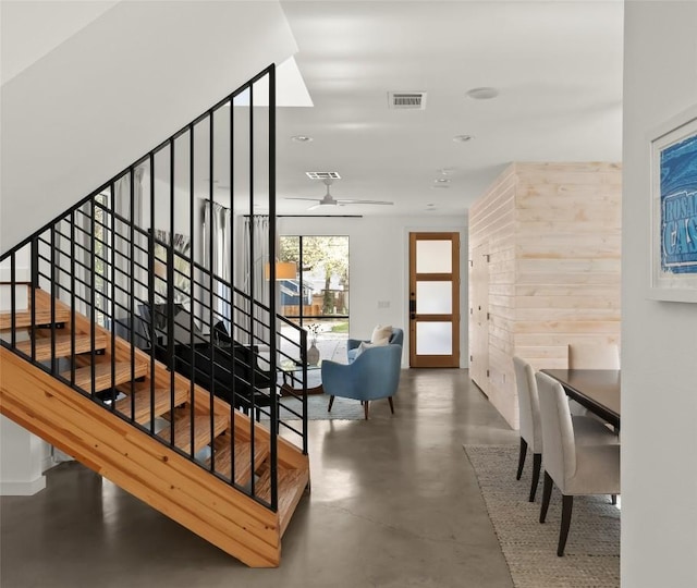 staircase with visible vents, ceiling fan, and finished concrete flooring