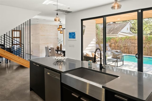 kitchen with dark cabinets, dark countertops, dishwasher, and a sink