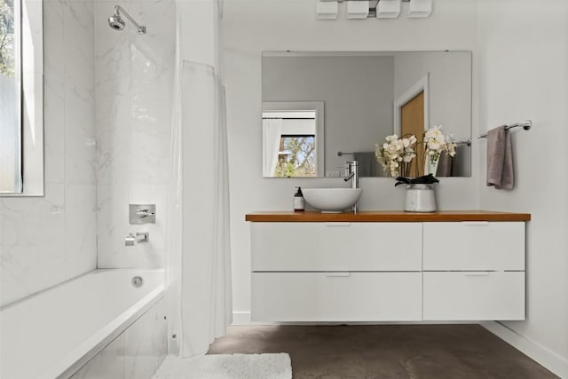 full bath featuring shower / tub combo, concrete floors, vanity, and baseboards