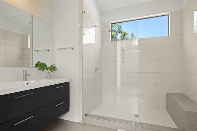 bathroom with tiled shower and vanity