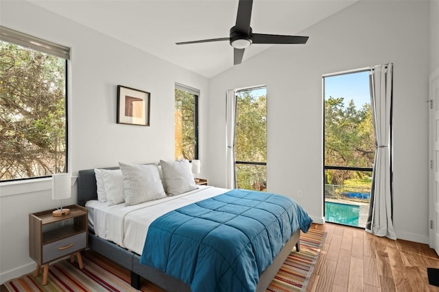 bedroom featuring ceiling fan, vaulted ceiling, baseboards, and wood finished floors