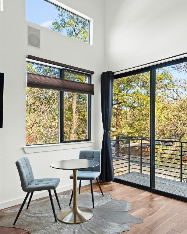 interior space featuring baseboards, a high ceiling, and wood finished floors