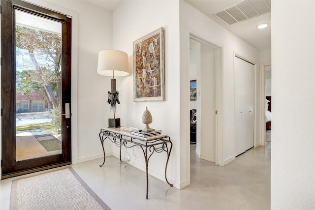 interior space featuring finished concrete flooring, baseboards, and visible vents