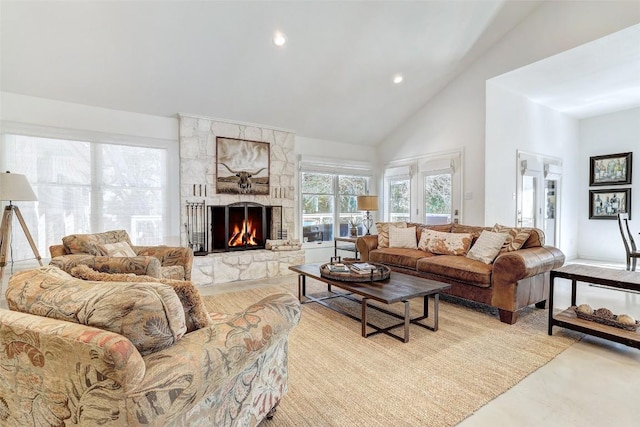 living room featuring recessed lighting, high vaulted ceiling, and a stone fireplace