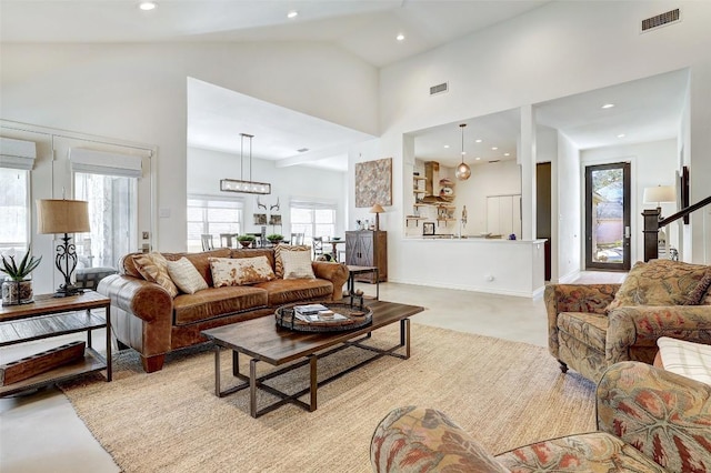 living area with high vaulted ceiling, visible vents, and recessed lighting