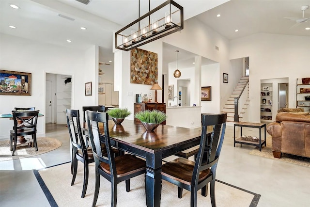 dining area with recessed lighting, ceiling fan, high vaulted ceiling, concrete flooring, and stairs