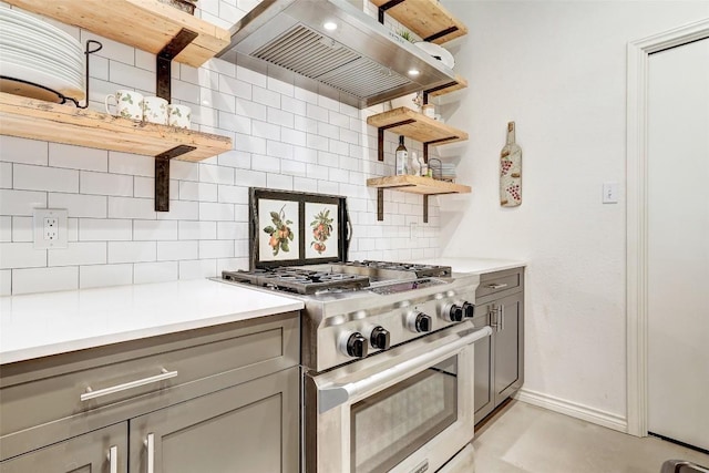 kitchen with stainless steel stove, open shelves, gray cabinetry, and exhaust hood