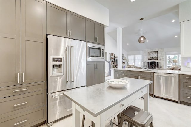 kitchen featuring vaulted ceiling, stainless steel appliances, gray cabinetry, light countertops, and a sink