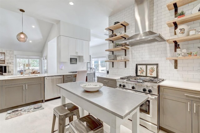 kitchen with open shelves, stainless steel appliances, gray cabinets, a sink, and wall chimney range hood