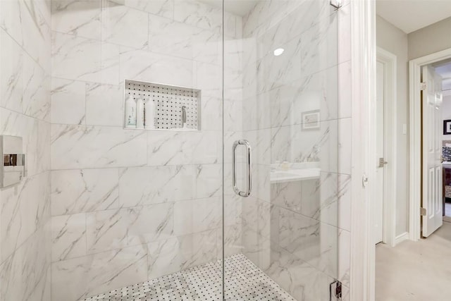 bathroom featuring a marble finish shower