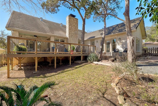 back of property featuring fence, a chimney, and a wooden deck