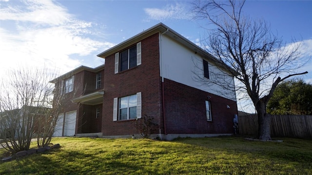 view of side of home featuring a garage, a yard, fence, and brick siding