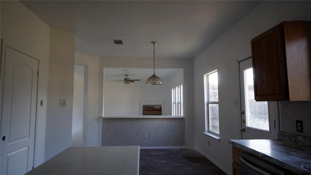 kitchen featuring baseboards, visible vents, a ceiling fan, dishwasher, and pendant lighting