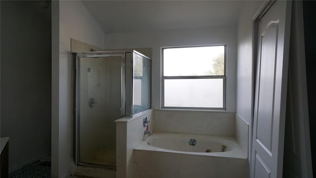 bathroom featuring a shower stall and a bath