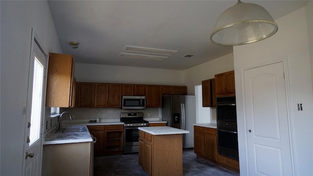 kitchen with a center island, light countertops, decorative backsplash, appliances with stainless steel finishes, and a sink