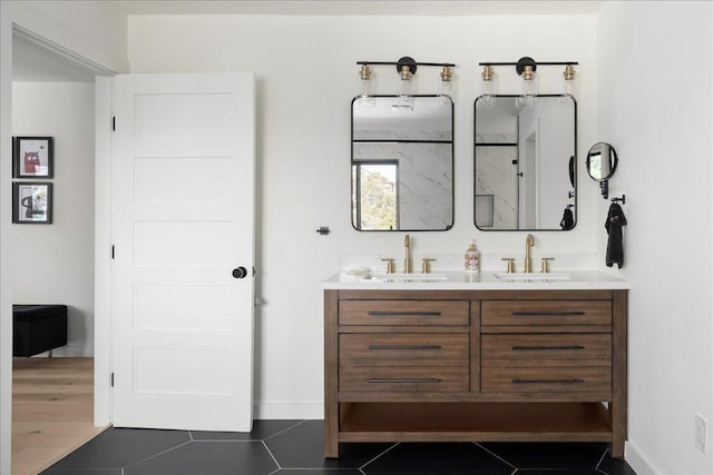 full bathroom featuring double vanity, tile patterned flooring, a sink, and baseboards