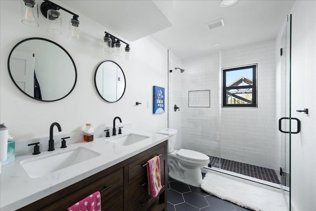 full bath with double vanity, a stall shower, visible vents, and a sink