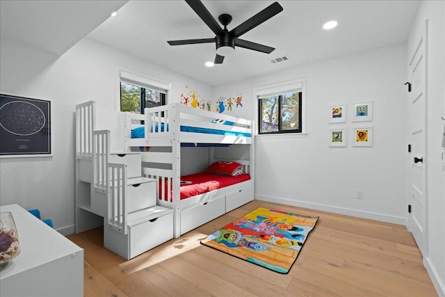 bedroom with baseboards, visible vents, wood finished floors, and recessed lighting