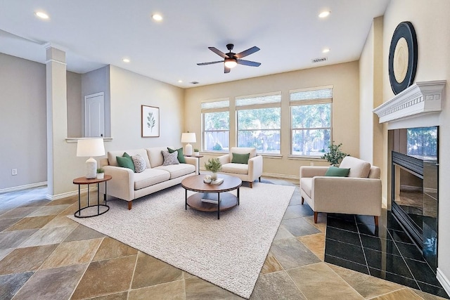 living room with recessed lighting, a premium fireplace, a ceiling fan, baseboards, and stone finish flooring