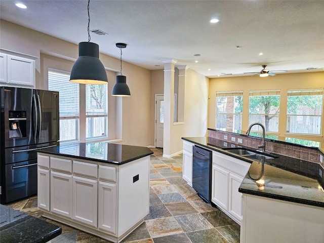 kitchen featuring black appliances, an island with sink, a sink, a ceiling fan, and white cabinetry