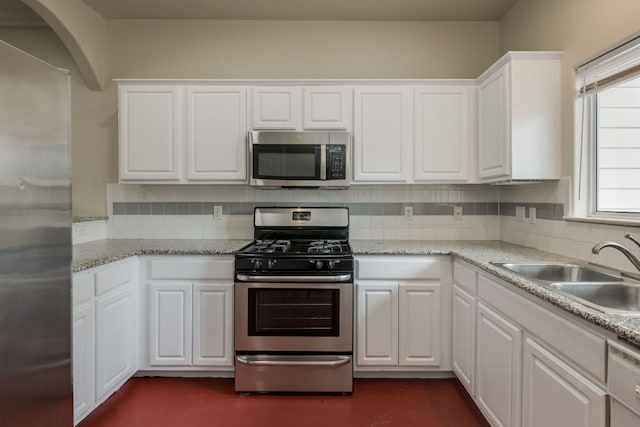 12249 Abbey Glen Ln Unit B, Austin, TX 78753 - kitchen featuring appliances with stainless steel finishes, a sink, backsplash, and white cabinetry