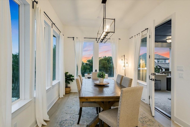 dining space with light wood-style flooring and an inviting chandelier