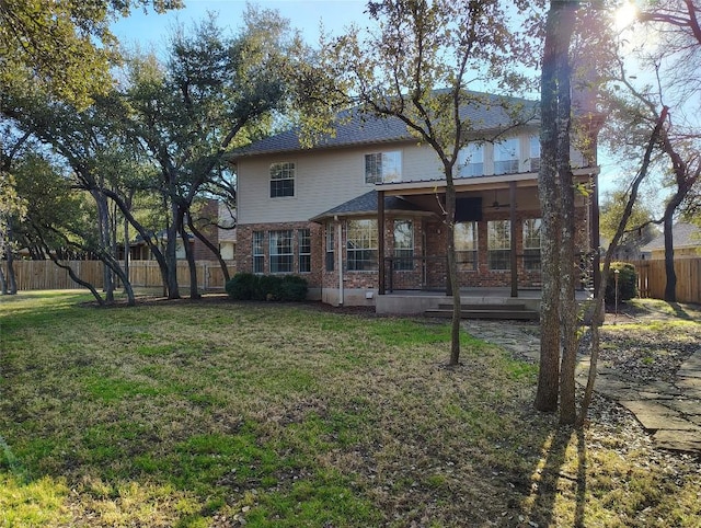 back of house with a yard, brick siding, and fence private yard