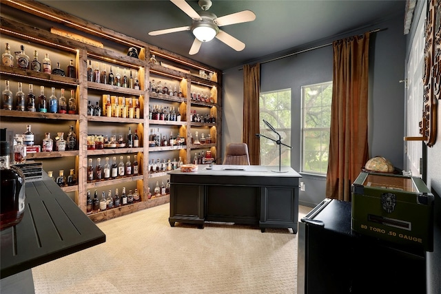 office space with light carpet, a dry bar, and ceiling fan