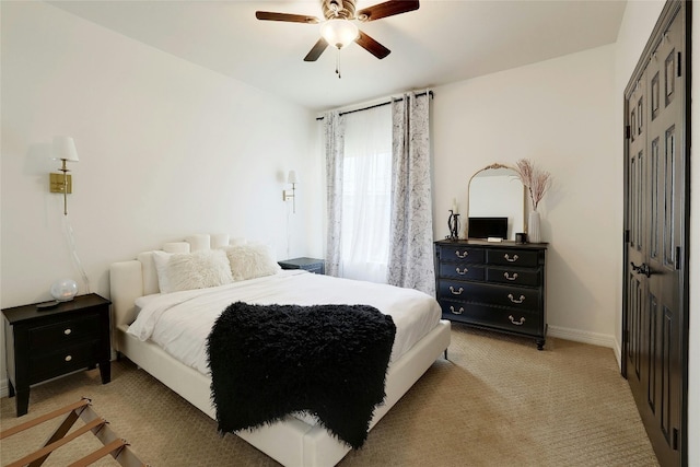 bedroom with light carpet, a closet, baseboards, and a ceiling fan