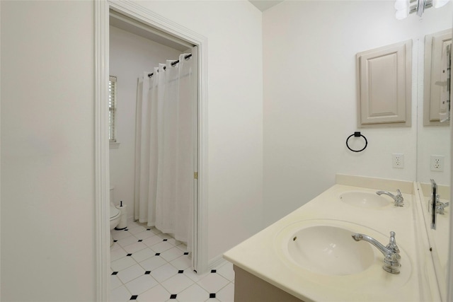 bathroom with double vanity, a shower with curtain, toilet, and a sink