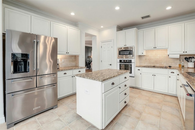 kitchen featuring stainless steel appliances, visible vents, light stone counters, and white cabinetry