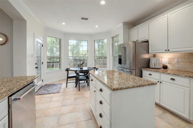 kitchen with ornamental molding, stainless steel appliances, tasteful backsplash, and visible vents