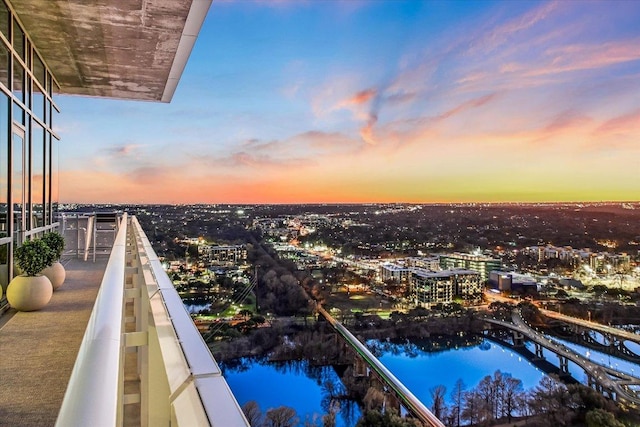 balcony at dusk featuring a view of city