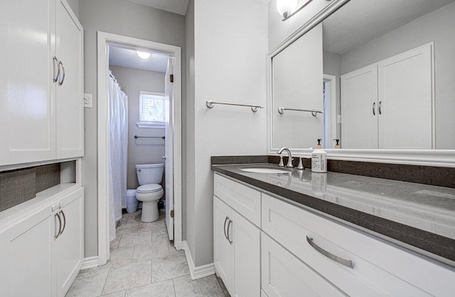 bathroom with baseboards, vanity, and toilet