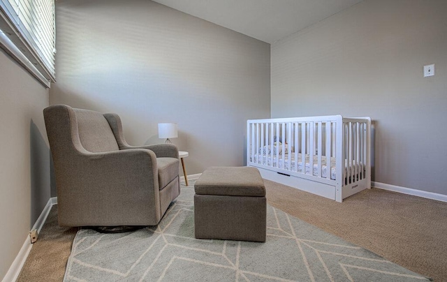 carpeted bedroom with a nursery area and baseboards