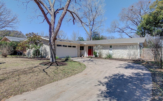 single story home with concrete driveway and an attached garage