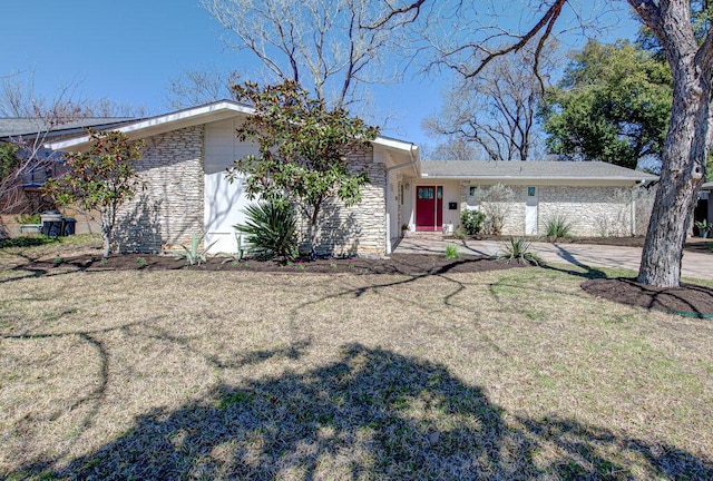 mid-century inspired home with stone siding and a front lawn