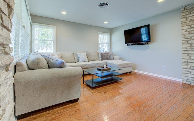 living area with recessed lighting, light wood-type flooring, visible vents, and baseboards