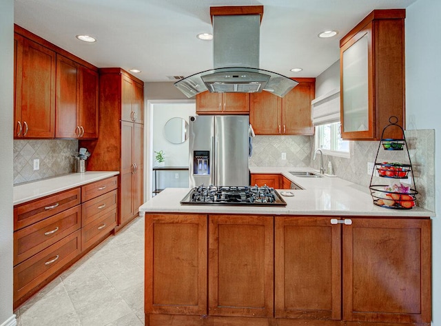 kitchen with a sink, black gas stovetop, island range hood, stainless steel fridge, and a peninsula