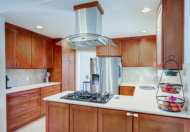 kitchen featuring stainless steel fridge, island exhaust hood, light countertops, a sink, and black gas stovetop