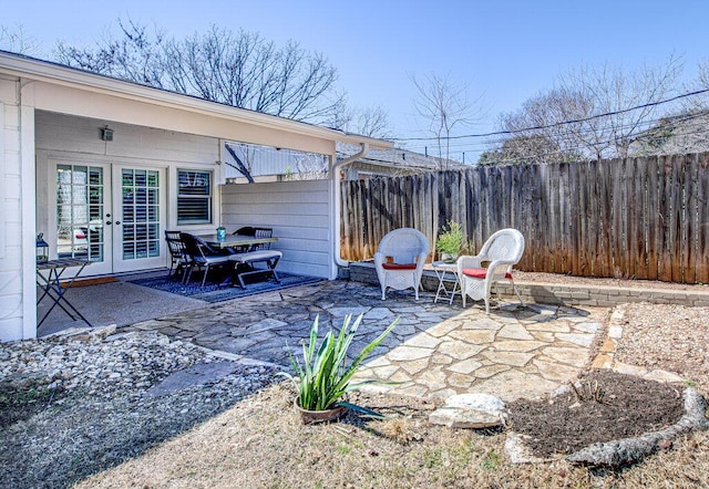 view of patio featuring french doors and fence