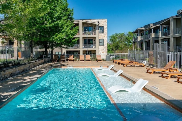 community pool featuring fence and a patio