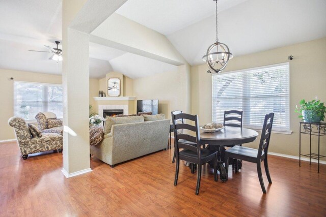 16710 Sabertooth Dr, Round Rock, TX 78681 - dining area featuring vaulted ceiling, wood finished floors, a ceiling fan, a tile fireplace, and baseboards